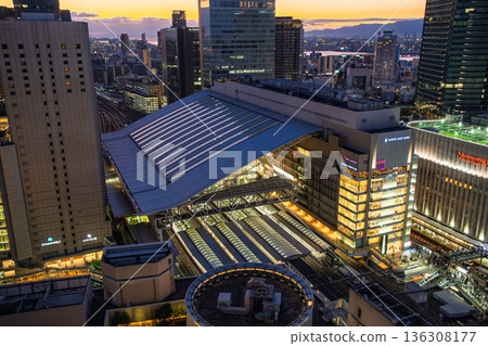 Osaka City: A bird's-eye view of the twilight sky and the large roof and platform of JR Osaka Station 136308177