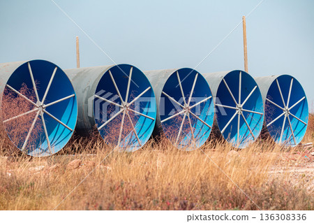 Steel Large diameter pipes are stacked in an industrial factory at construction site. Steel Large diameter pipes are stacked in an industrial factory at construction site. 136308336