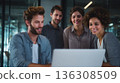 Team reviewing laptop in modern office 136308509