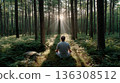 Man meditating in forest with sun rays 136308512