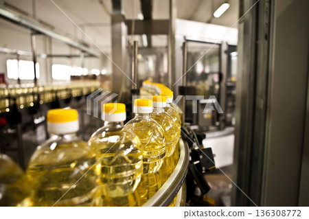 Automated production line bottling golden sunflower oil in a modern food manufacturing plant 136308772
