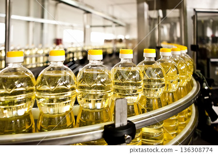 Automated production line bottling golden sunflower oil in a modern food manufacturing plant 136308774