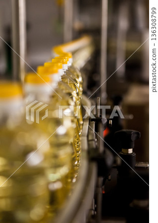 Automated production line bottling golden sunflower oil in a modern food manufacturing plant 136308799