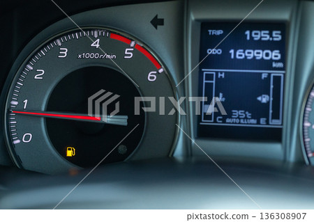 Empty fuel warning light in car dashboard. Fuel pump icon.  136308907