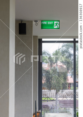 Green emergency exit sign showing the way to escape. Fire exit in the building. 136308917