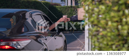 Hand Man in car receiving coffee in drive thru fast food restaurant. Hand Man in car receiving coffee in drive thru fast food restaurant. 136308977