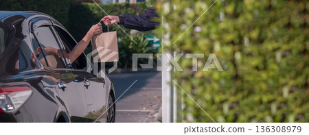 Hand Man in car receiving coffee in drive thru fast food restaurant. 136308979