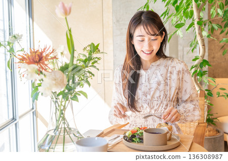 年輕女子在咖啡館吃午餐 136308987