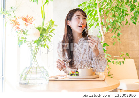 年輕女子在咖啡館吃午餐 136308990