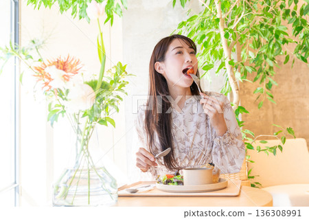 Young woman having lunch at a cafe Young woman having lunch at a cafe 136308991