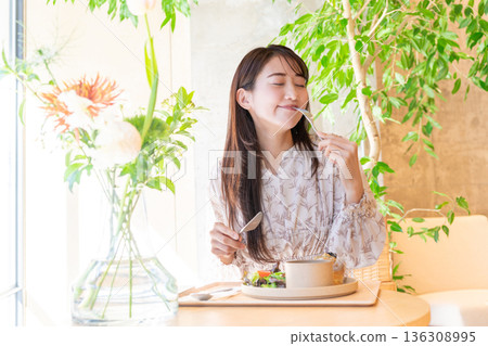 Young woman having lunch at a cafe Young woman having lunch at a cafe 136308995