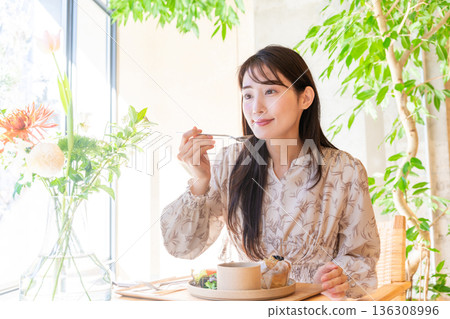 Young woman having lunch at a cafe Young woman having lunch at a cafe 136308996
