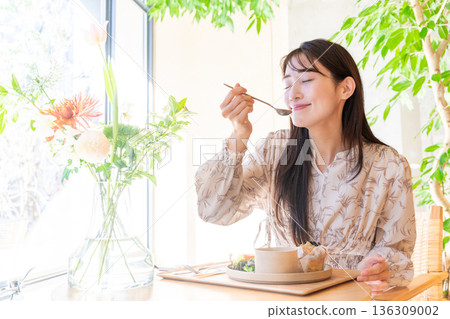 Young woman having lunch at a cafe Young woman having lunch at a cafe 136309002