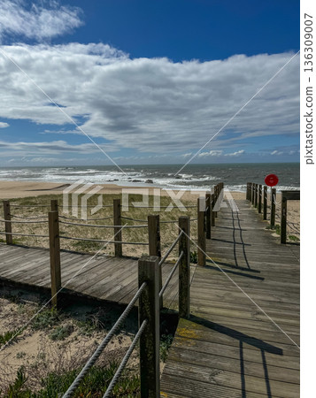 Wooden boardwalk leading to sandy beach and Atlantic Ocean along the Camino de Santiago coastal route under dramatic clouds, travel, pilgrimage and seaside tourism concepts Wooden boardwalk leading to sandy beach and Atlantic Ocean along the Camino de Santiago coastal route under dramatic clouds, travel, pilgrimage and seaside tourism concepts 136309007
