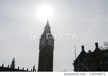 London's Westminster and its large clock tower, Big Ben, backlit under a slightly cloudy sky 136309072