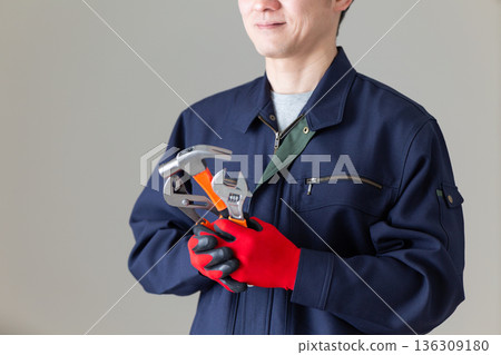 Middle-aged male businessman in work clothes holding tools 136309180