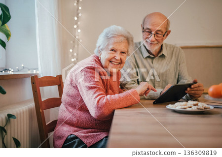 Senior coule working with tablet, making reservation or shopping online. Senior coule working with tablet, making reservation or shopping online. 136309819
