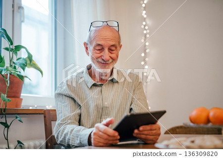 Elderly man using tablet, shopping online. 136309820