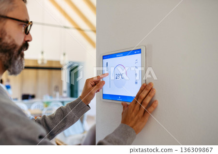 Man using smart home control panel. Man using smart home control panel. 136309867