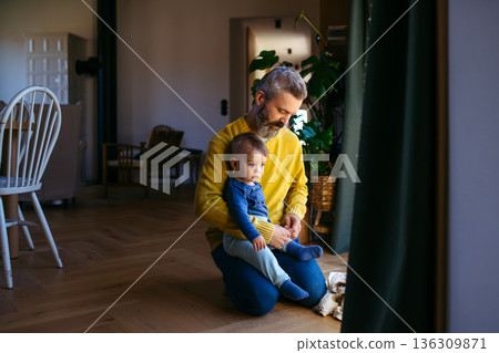 Father with little toddler son looking out of window. 136309871
