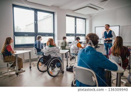 Inclusive classroom scene with student using wheelchair. 136309940