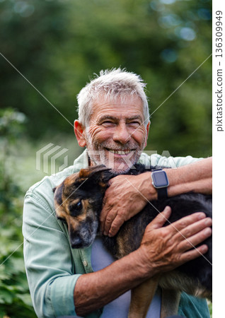 Older man spending quality time with dog, natural setting. Older man spending quality time with dog, natural setting. 136309949