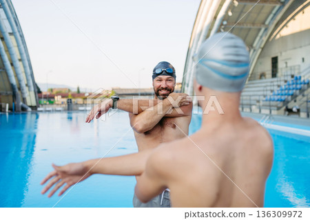 Father and teenage son enjoying swim training together. 136309972
