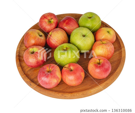 Red and green apples on a wooden plate isolated on white. Red and green apples on a wooden plate isolated on white. 136310086