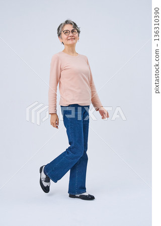 一位微笑的老婦人正在散步 136310390