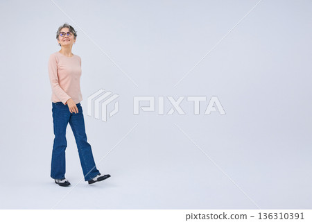 一位微笑的老婦人正在散步 136310391