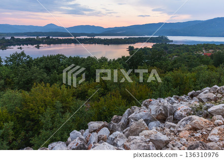 A tranquil landscape featuring a rocky foreground A tranquil landscape featuring a rocky foreground 136310976