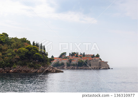 A tranquil coastal village sits on a rocky peninsula 136310977