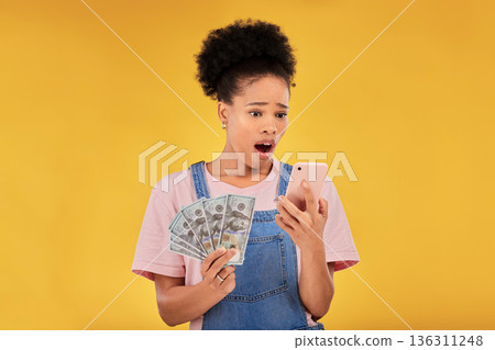 Surprise, money and winner with black woman and phone in studio for success, prize or deal. Bonus, lottery and online payment with person and cash on yellow background for dollar, profit or giveaway Surprise, money and winner with black woman and phone in studio for success, prize or deal. Bonus, lottery and online payment with person and cash on yellow background for dollar, profit or giveaway 136311248