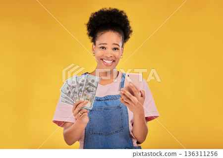 Phone, money and winner with portrait of black woman in studio for success, prize or online payment. Bonus, lottery and fintech with person and cash on yellow background for dollar, sale or giveaway Phone, money and winner with portrait of black woman in studio for success, prize or online payment. Bonus, lottery and fintech with person and cash on yellow background for dollar, sale or giveaway 136311256