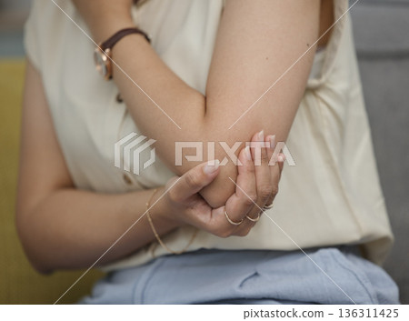 Elbow pain, woman with injury and muscle tension, fibromyalgia or arthritis with health problem. Female person is sick, inflammation and tension in joint with closeup, medical condition and fracture Elbow pain, woman with injury and muscle tension, fibromyalgia or arthritis with health problem. Female person is sick, inflammation and tension in joint with closeup, medical condition and fracture 136311425