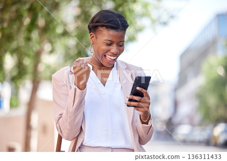 Business woman, phone and celebrate outdoor on a city road for success, achievement or win. Excited black female entrepreneur with a smartphone on sidewalk for online competition or bank notification Business woman, phone and celebrate outdoor on a city road for success, achievement or win. Excited black female entrepreneur with a smartphone on sidewalk for online competition or bank notification 136311433