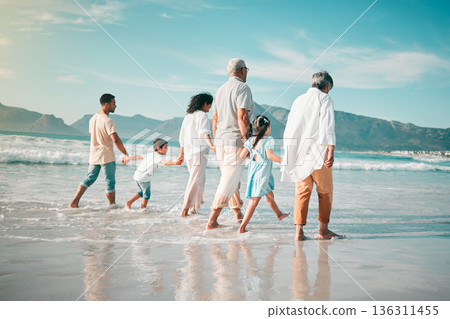 Holding hands, family is walking on beach with ocean and back view, solidarity and bonding in nature. Generations, people outdoor on tropical holiday and freedom, travel with trust and love in Mexico Holding hands, family is walking on beach with ocean and back view, solidarity and bonding in nature. Generations, people outdoor on tropical holiday and freedom, travel with trust and love in Mexico 136311455