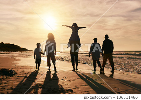 Silhouette, family is walking on beach and back view with ocean waves, sunset and bonding in nature. Generations, people outdoor and tropical holiday, freedom and travel with trust and love in Mexico Silhouette, family is walking on beach and back view with ocean waves, sunset and bonding in nature. Generations, people outdoor and tropical holiday, freedom and travel with trust and love in Mexico 136311460