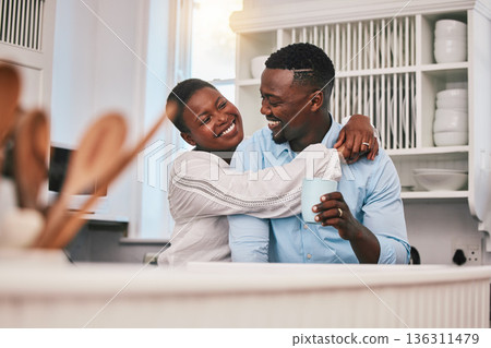 Coffee, hug or happy black couple in kitchen talking or laughing to relax with love or care at home. Smile, morning or African man speaking to woman with tea drink bonding in conversation together Coffee, hug or happy black couple in kitchen talking or laughing to relax with love or care at home. Smile, morning or African man speaking to woman with tea drink bonding in conversation together 136311479