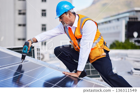 Solar panels, man and power drill for engineering, grid and building maintenance in city. Electrician, construction tools and inspection of energy saving electricity, photovoltaic system and rooftop Solar panels, man and power drill for engineering, grid and building maintenance in city. Electrician, construction tools and inspection of energy saving electricity, photovoltaic system and rooftop 136311549