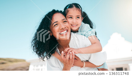 Hug, piggyback and mom with her girl child playing outdoor in the garden at their family home. Happy, smile and young mother carrying her kid on her back bonding and playing together in the backyard. 136311748
