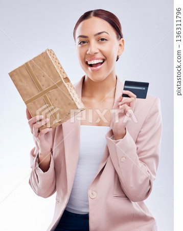Gift, portrait and happy woman with credit card in studio, wow and smile for cashback gift on grey background. Customer, reward and female face with box present promotion for retail, sale or payment 136311796