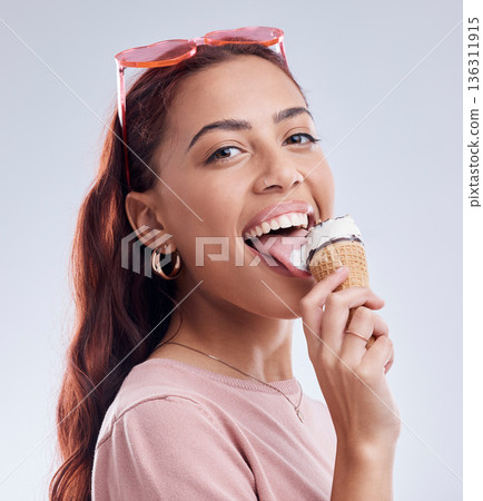 Summer, ice cream and portrait of woman with smile in studio with dessert, snack and sweet treats. Happy, sunglasses and face of female person with cone in trendy accessories, style and cosmetics Summer, ice cream and portrait of woman with smile in studio with dessert, snack and sweet treats. Happy, sunglasses and face of female person with cone in trendy accessories, style and cosmetics 136311915