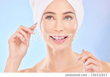 Happy woman, face and thinking with dental floss for teeth cleaning or hygiene against a blue studio background. Female person in wonder, flossing or self love for tooth whitening, oral and gum care 136312017