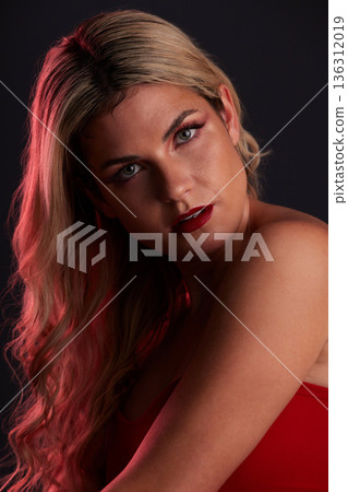 Portrait, luxury and makeup with a model woman in studio on a dark background in red lighting for desire. Face, beauty or skincare with a young female person posing for natural feminine confidence Portrait, luxury and makeup with a model woman in studio on a dark background in red lighting for desire. Face, beauty or skincare with a young female person posing for natural feminine confidence 136312019