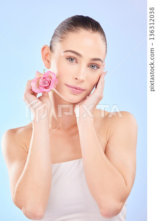 Woman, portrait and rose for skincare in studio, eco cosmetics and natural aesthetic facial on blue background. Face, female model and beauty of pink flowers, sustainable shine and floral dermatology Woman, portrait and rose for skincare in studio, eco cosmetics and natural aesthetic facial on blue background. Face, female model and beauty of pink flowers, sustainable shine and floral dermatology 136312038