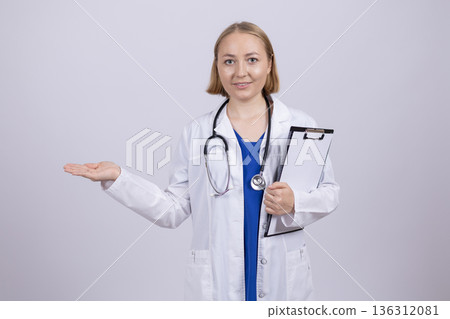 Female doctor in white lab coat presenting copy space Female doctor in white lab coat presenting copy space 136312081