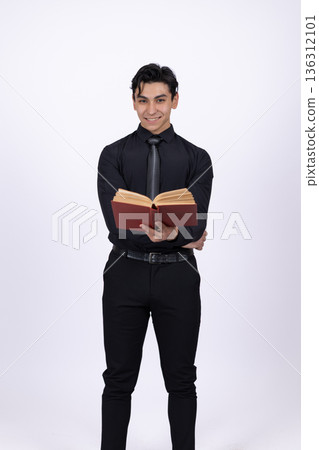 Young man in black shirt holding a book and posing Young man in black shirt holding a book and posing 136312101