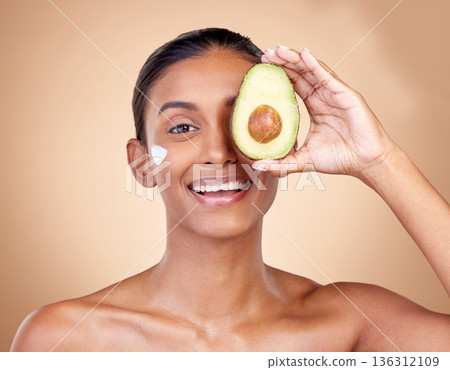 Avocado, cream and beauty with portrait of woman in studio for product, skincare and natural cosmetics. Spa, facial and lotion with face of model on brown background for vitamin c and self care 136312109