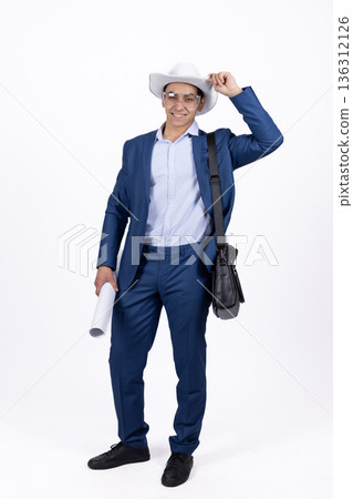 Young man in blue suit holding a blazer over his shoulder 136312126
